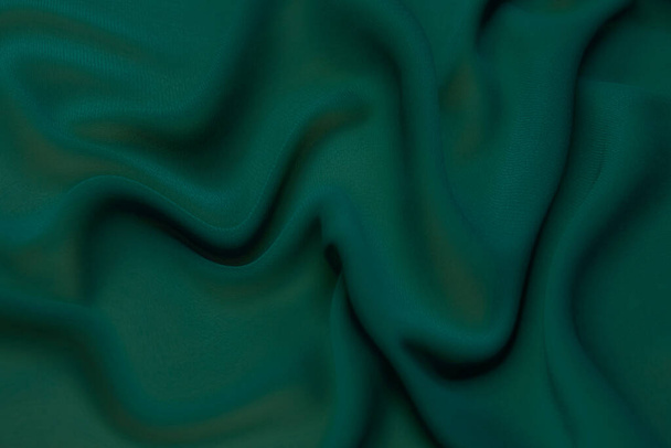 Struktura, pozadí, vzorec. Struktura zelené hedvábné tkaniny. Krásná smaragdová zelená měkká hedvábná tkanina. - Fotografie, Obrázek