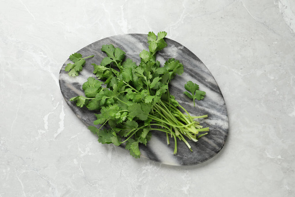Bunch of fresh aromatic cilantro on light marble table, top view - Fotografie, Obrázek