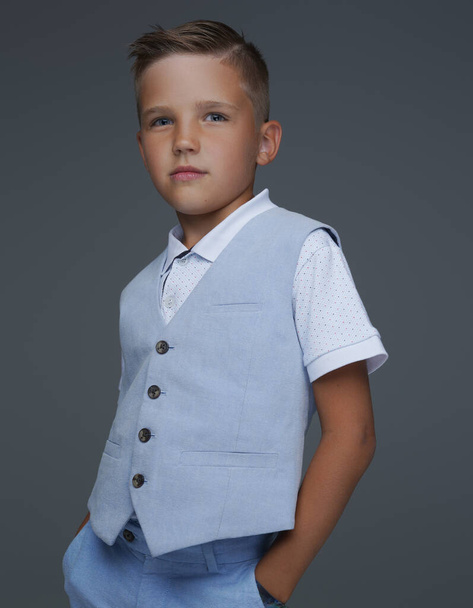 Confident preschool boy posing against gray background - Photo, Image