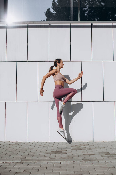 Beyaz tenli, spor yapan, spor yapan, spor yapan, şehirde yoga yapan genç bir kadının yan görüntüsü.. - Fotoğraf, Görsel