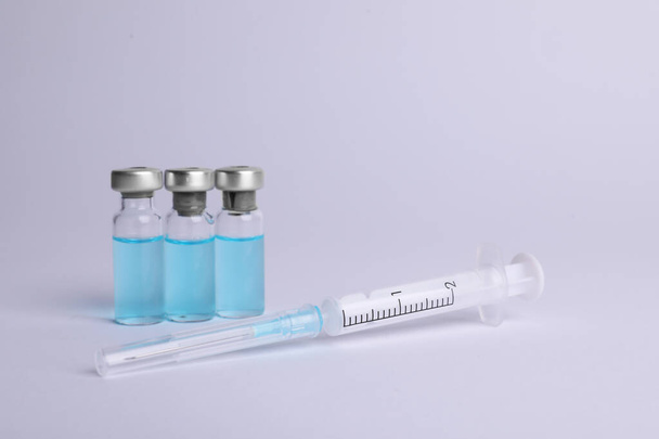 Disposable syringe with needle and vials on white background - Fotografie, Obrázek