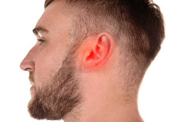 Jeune homme avec problème auditif sur fond blanc, gros plan - Photo, image