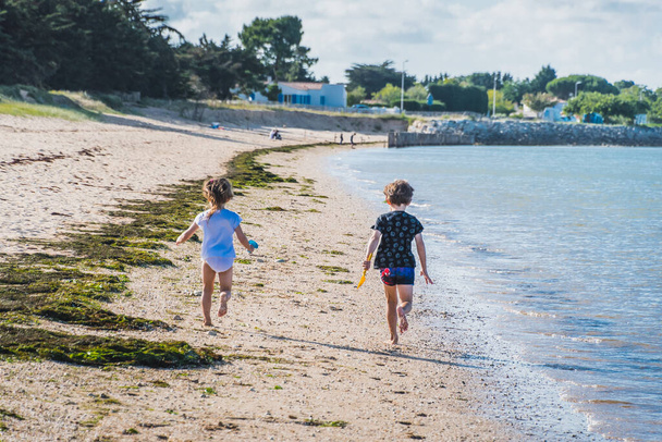 Παιδιά που τρέχουν στην παραλία La Phibie στο νησί Oleron στη Γαλλία - Φωτογραφία, εικόνα