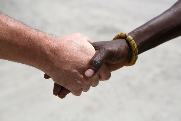 kézfogás a kaukázusi és egy afrikai között - Fotó, kép