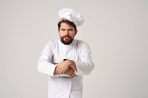 Fröhlicher männlicher Koch mit einer Pfanne in den Händen eines professionellen Kochers - Foto, Bild