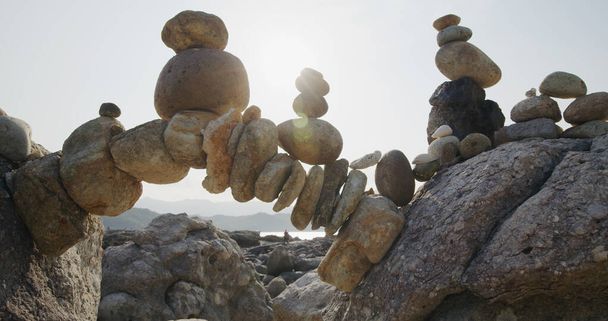 Łuk kamyków w równowadze na wybrzeżu morskim - Zdjęcie, obraz