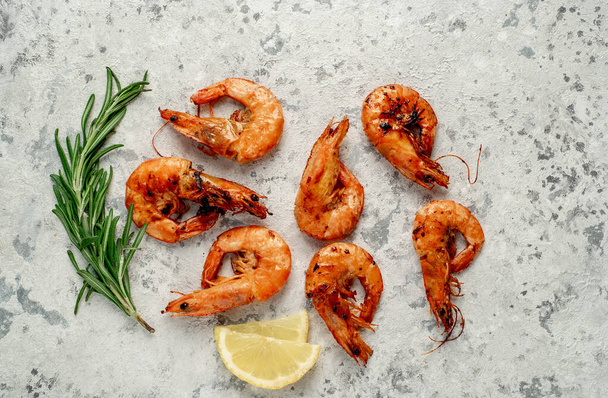 grilled shrimps with lemon and rosemary on black background. top view. - 写真・画像