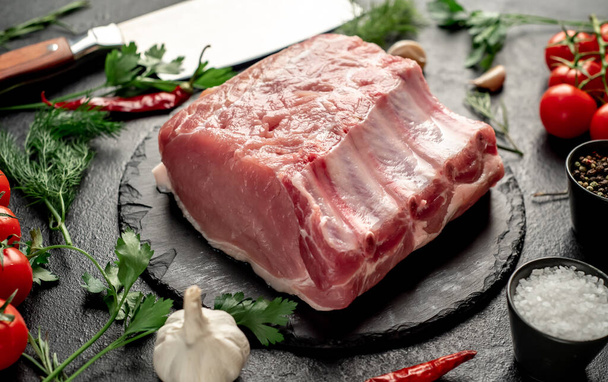 syrový hovězí steak s kořením a bylinkami na černém pozadí - Fotografie, Obrázek