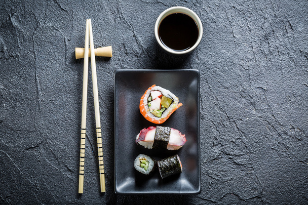 Sushi servi sur une céramique noire avec sauce soja
 - Photo, image