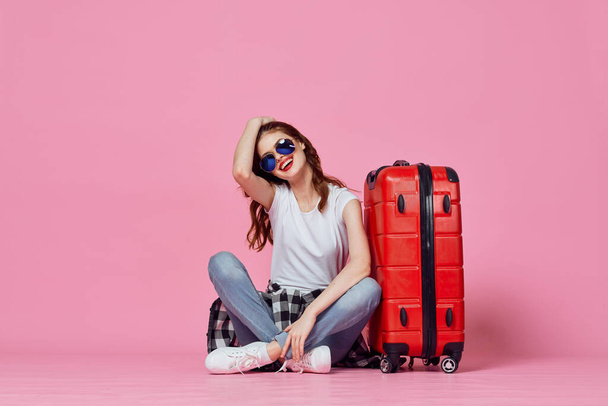 жінка з червоною валізою паспорт і квиток на літак подорожі рожевий фон
 - Фото, зображення