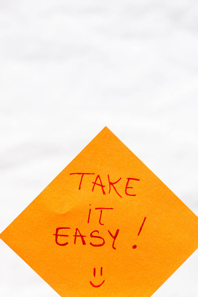 Prendilo testo calligrafia facile chiudere isolato su carta arancione con spazio su copia. - Foto, immagini