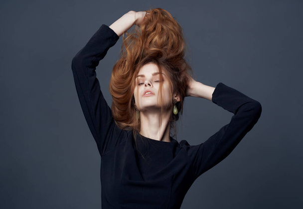 pretty woman in black dress holding hair fashion hairstyle attractive look - 写真・画像