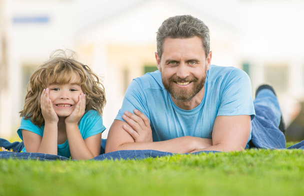 ευτυχισμένος πατέρας με το παιδί χαλαρώστε μαζί στο πράσινο γρασίδι πάρκο, την οικογένεια - Φωτογραφία, εικόνα