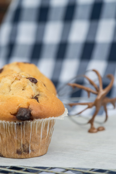 Tasty home made muffins with whisk covered in melting chocolate - Photo, Image