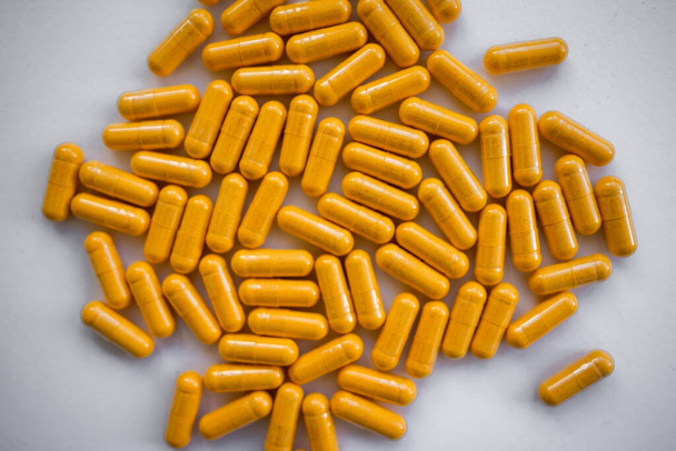 Gele capsules op een witte achtergrond - Foto, afbeelding