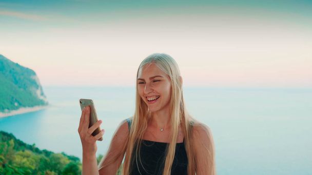 Όμορφη γυναίκα που παρέχει βιντεοκλήση με θέα στον ωκεανό - Φωτογραφία, εικόνα