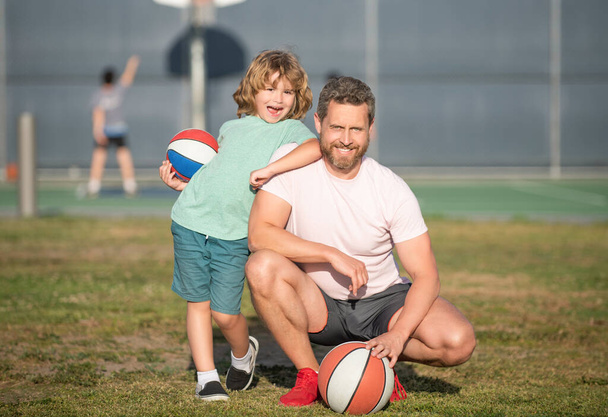 onnellinen isä ja lapsi pelaa koripalloa pallo ulkona, lapsuus - Valokuva, kuva