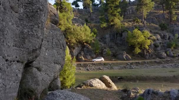 Vidéki hegyvidéki táj autóval a vidéki úton és sziklás lejtőn. - Felvétel, videó