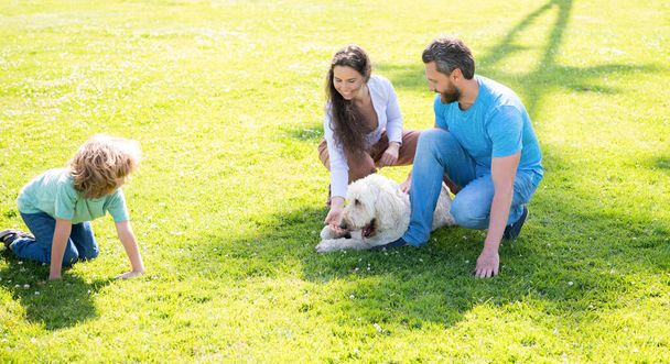 heureux famille de maman père et enfant fils jouer avec chien de compagnie dans le parc d'été herbe verte, amoureux de chien - Photo, image