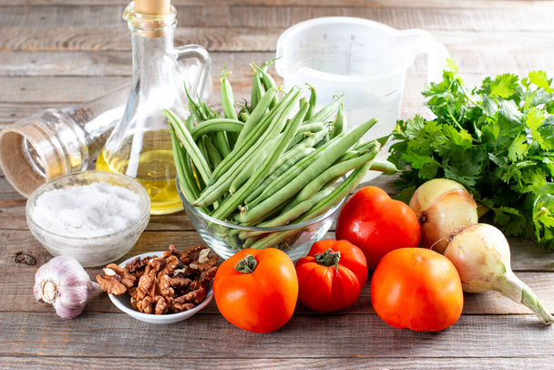 Ингредиенты для приготовления лобио зеленой фасоли с овощами и помидорами. Шаг за шагом рецепт. Здоровое питание. - Фото, изображение