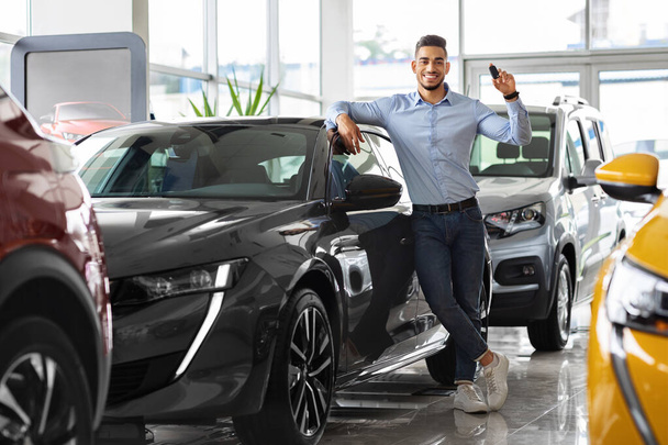 Стильний арабський чоловік тримає ключ від автомобіля і посміхається
 - Фото, зображення