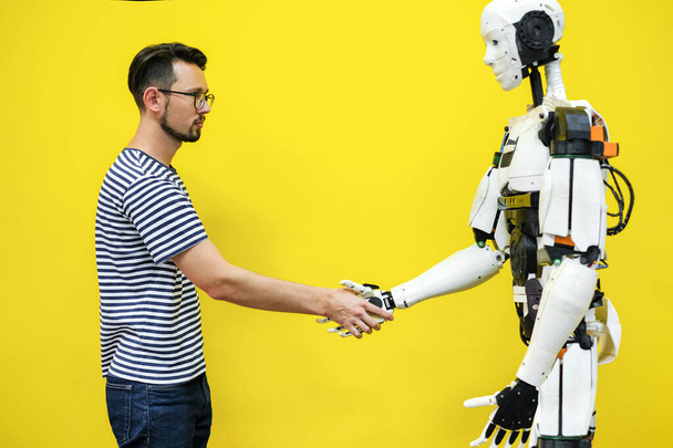 Een man schudt handen met een robot. ingenieur om een robot te maken. robotica toekomstconcept - Foto, afbeelding