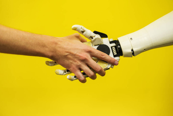 muž si potřese rukou s robotem zblízka. inženýr pro vytvoření robota. budoucí koncepce robotiky - Fotografie, Obrázek