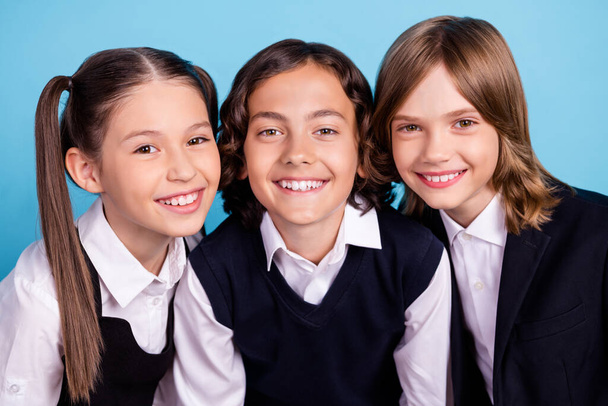 Foto retrato escola companheiros sorrindo em uniforme alegre alegre alegre isolado pastel azul cor fundo - Foto, Imagem