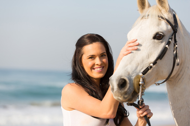 Happy woman comforting her horse - Photo, image