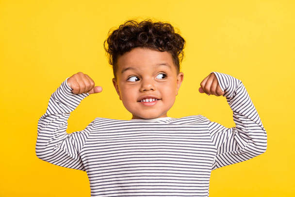 Photo portrait cheerful small boy looking blank space showing strong hands isolated bright yellow color background - Fotó, kép