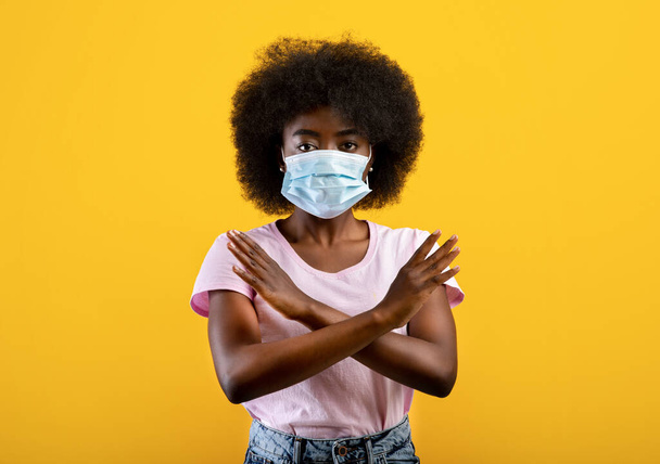 アフリカ系アメリカ人の女性は手で停止ジェスチャー医療面マスクを身に着けています,コロナウイルスの隔離にノーと言って - 写真・画像