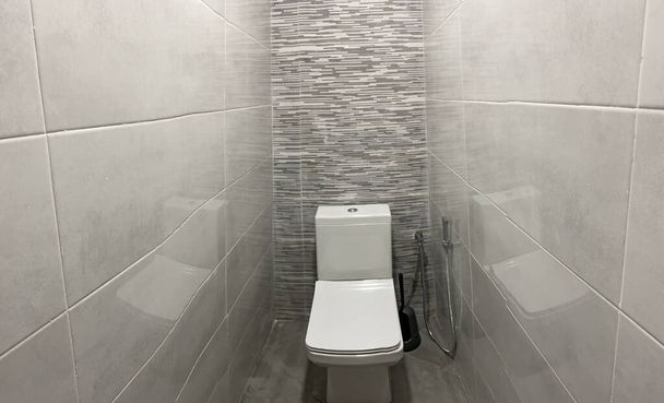 Elegant interior of a White toilet in the bathroom with gray ceramic on the walls - Фото, зображення