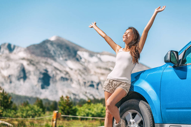 Happy road trip tourist girl enjoying driving sport car on summer travel adventure freedom vacation. Asian woman with open arms in freedom - Foto, immagini