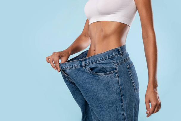 Close Up Of Woman Pulling Her Old Large Loose Jeans - Photo, Image