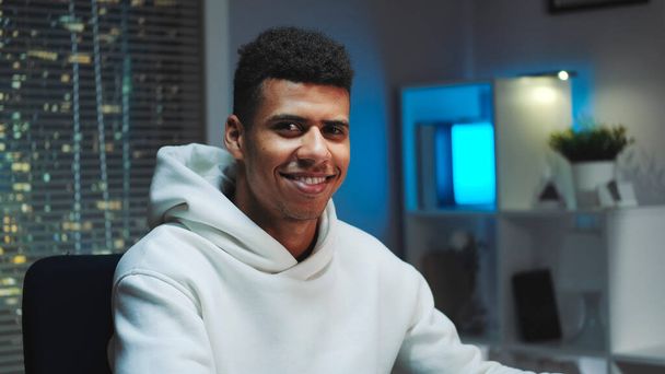 Close-up shot of Handsome black man smiling to the camera while working home - Zdjęcie, obraz