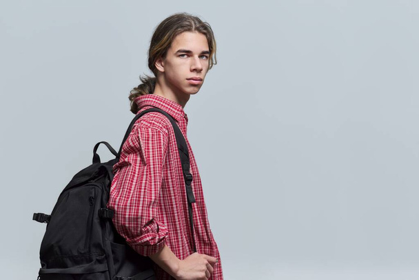 Guy student teenager with backpack looking at camera on light background - Foto, Bild