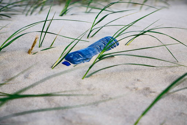 muovipullo hiekassa rannalla - Valokuva, kuva