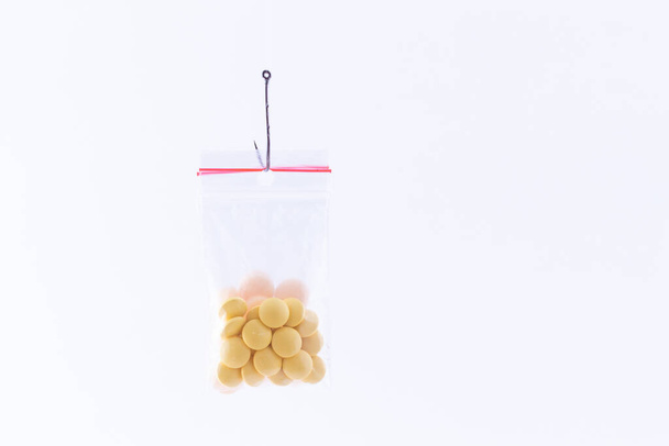Colored Pills or Tablets Hanging in Small Ziplock Bag on a Fishing Hook - Photo, Image