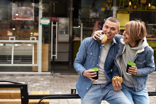 young couple drinking coffee while walking around the city - Φωτογραφία, εικόνα