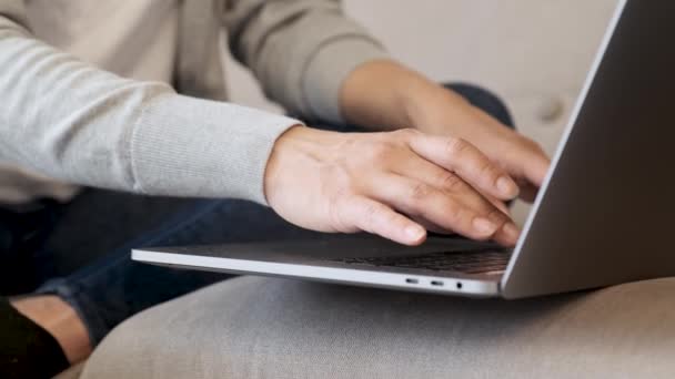 Blisko kobieta ręce pracy z laptopa w domu, palce są wpisując na klawiaturze laptopa w jasnym pokoju - Materiał filmowy, wideo