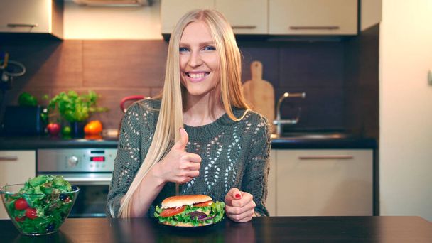 Jeune femme préférant hamburger à salade. - Photo, image