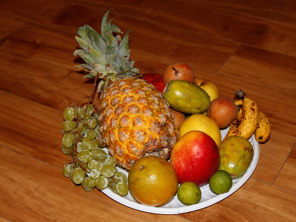 Tablett mit verschiedenen Früchten auf Holzoberfläche - Foto, Bild