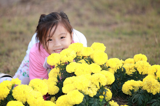 Piccola ragazza asiatica in un giardino fiorito
 - Foto, immagini