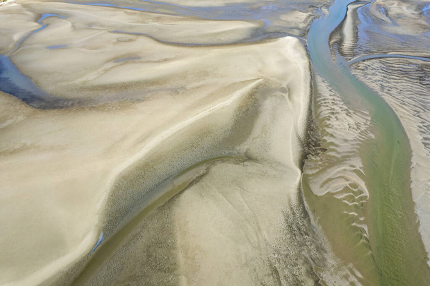 Krajobraz powietrzny oceanu podczas odpływu ukazujący brzegi piasku i wodę morską w abstrakcyjnych wzorach. Przylądek Hillsborough, Queensland, Australia - Zdjęcie, obraz