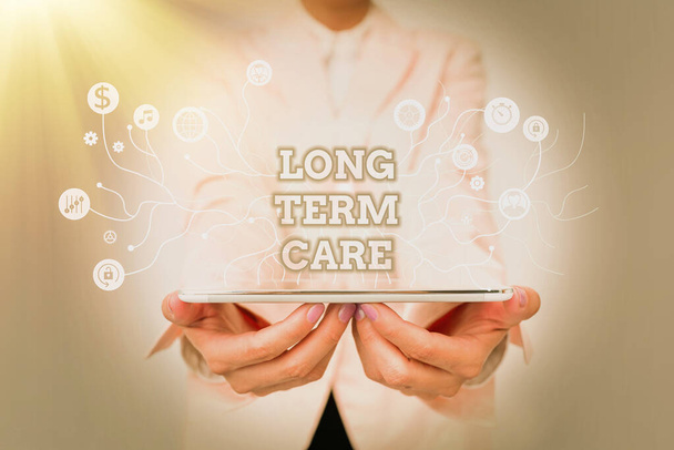 Handwriting text Long Term Care. Business showcase assistance with the basic personal tasks of everyday life Lady In Uniform Standing And Holding Tablet Showing Futuristic Technology. - Photo, Image