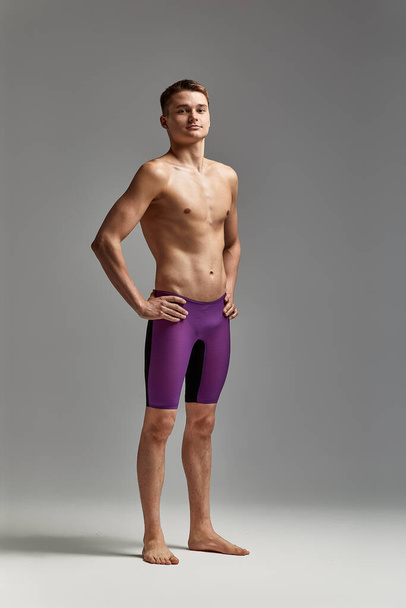 Retrato de um nadador em boné e máscara, retrato de meia-distância, jovem atleta nadador usando um boné e máscara para nadar, cópias do espaço, fundo cinza - Foto, Imagem