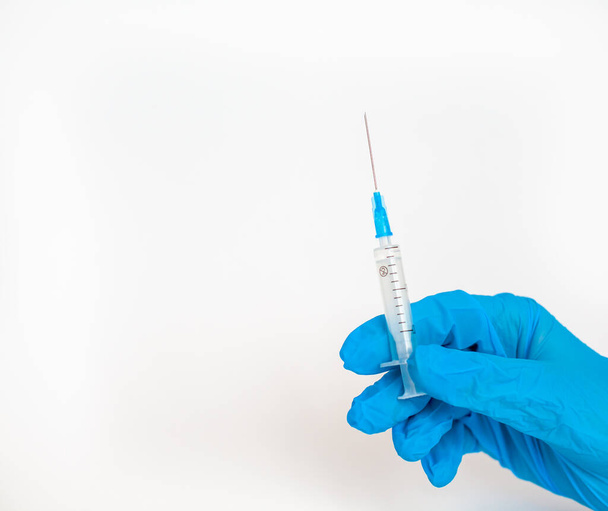 O médico segura uma seringa de vacinação num fundo branco. Um tiro do coronovírus. Vacinação contra infecções perigosas ou tratamento de doenças - Foto, Imagem