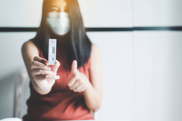 Patient woman showing result a covid-19 self test rapid antigen testing kit at home - Fotografie, Obrázek