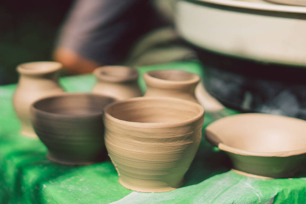 Potter fare un oggetto di argilla sulla ruota ceramica all'aperto. Argilla modellante artigianale con le mani sulla ruota della ceramica - Foto, immagini