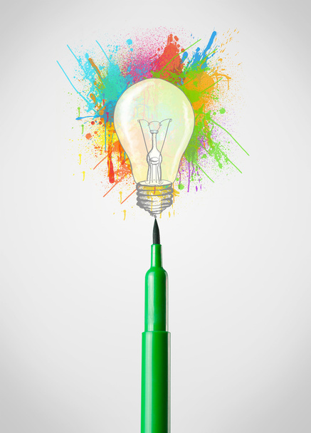 Фелтовая ручка крупным планом с цветными брызгами краски и лампочкой - Фото, изображение